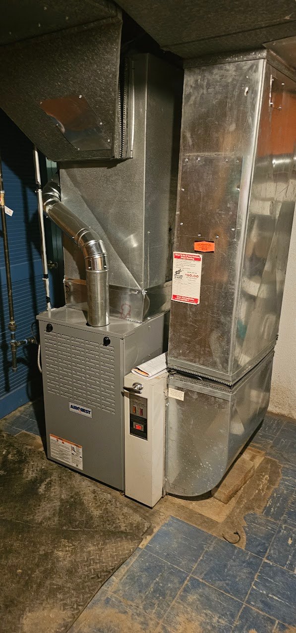 Technician inspecting an older furnace in a Detroit home basement